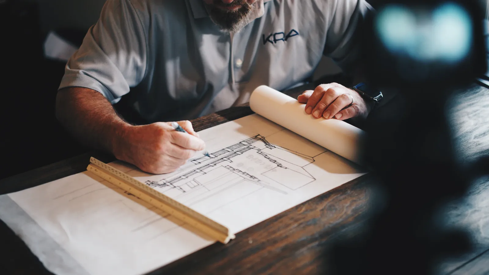 Architectural planning desk with infrastructure drawings and engineered material coordination.